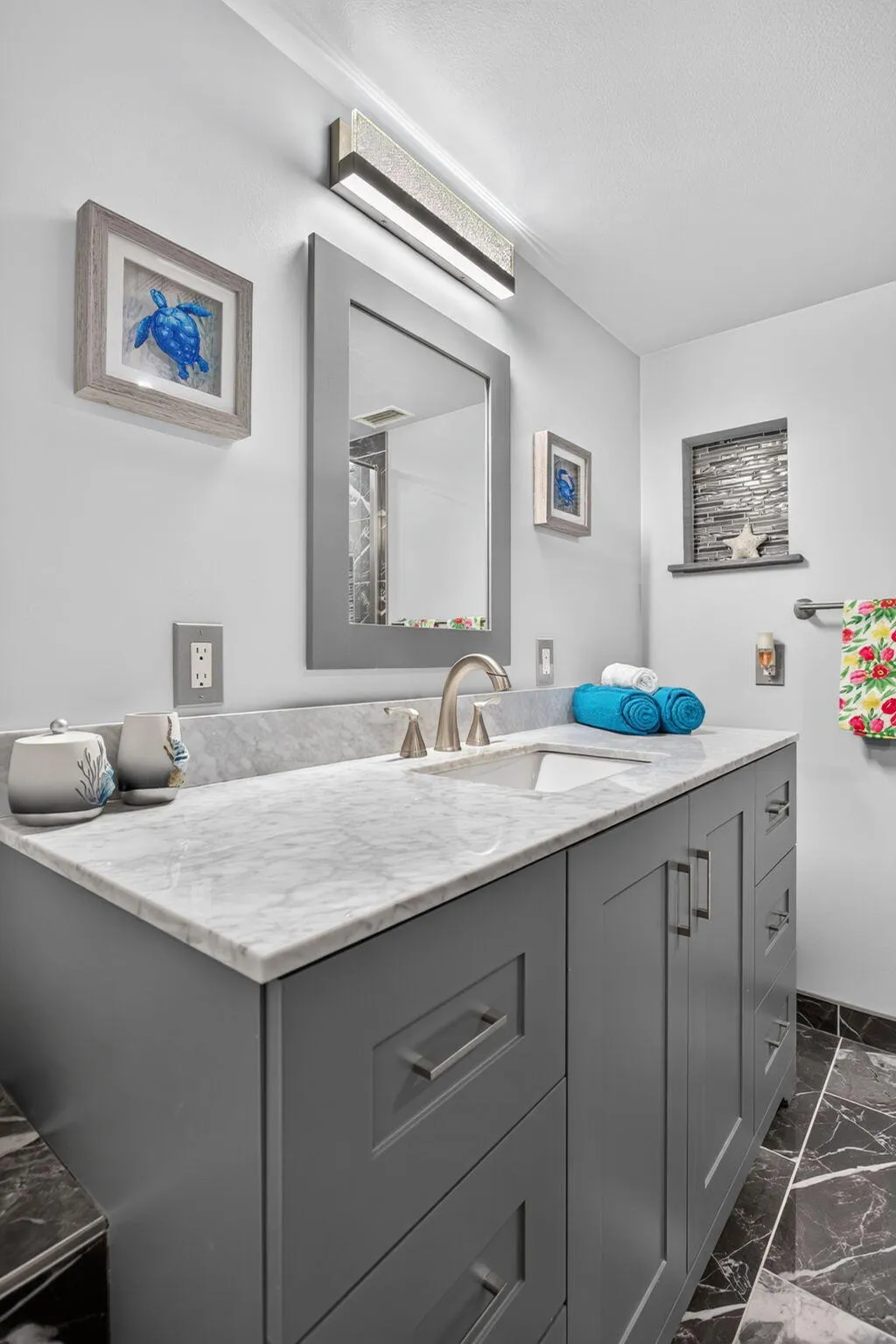 Primary bath features a counter height vanity with a marble top and undermount sink.