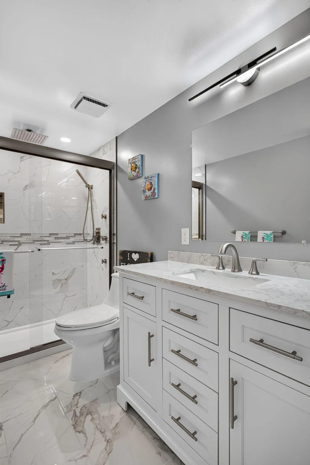 Stall shower with tile to the ceiling, pretty inlays and extra body jets.