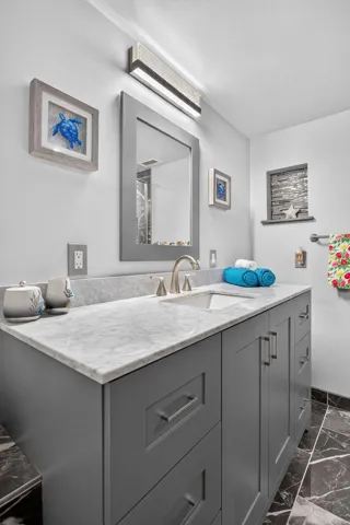 Primary bath features a counter height vanity with a marble top and undermount sink.