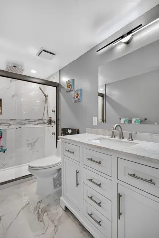 Stall shower with tile to the ceiling, pretty inlays and extra body jets.