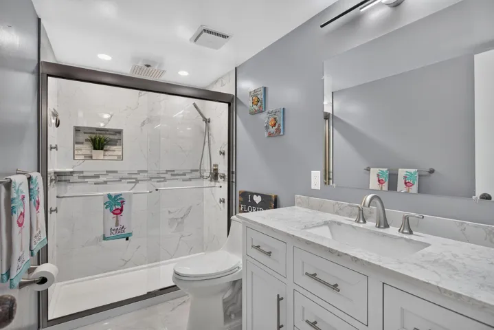 UPDATED guest bath features a counter height vanity with marble top.