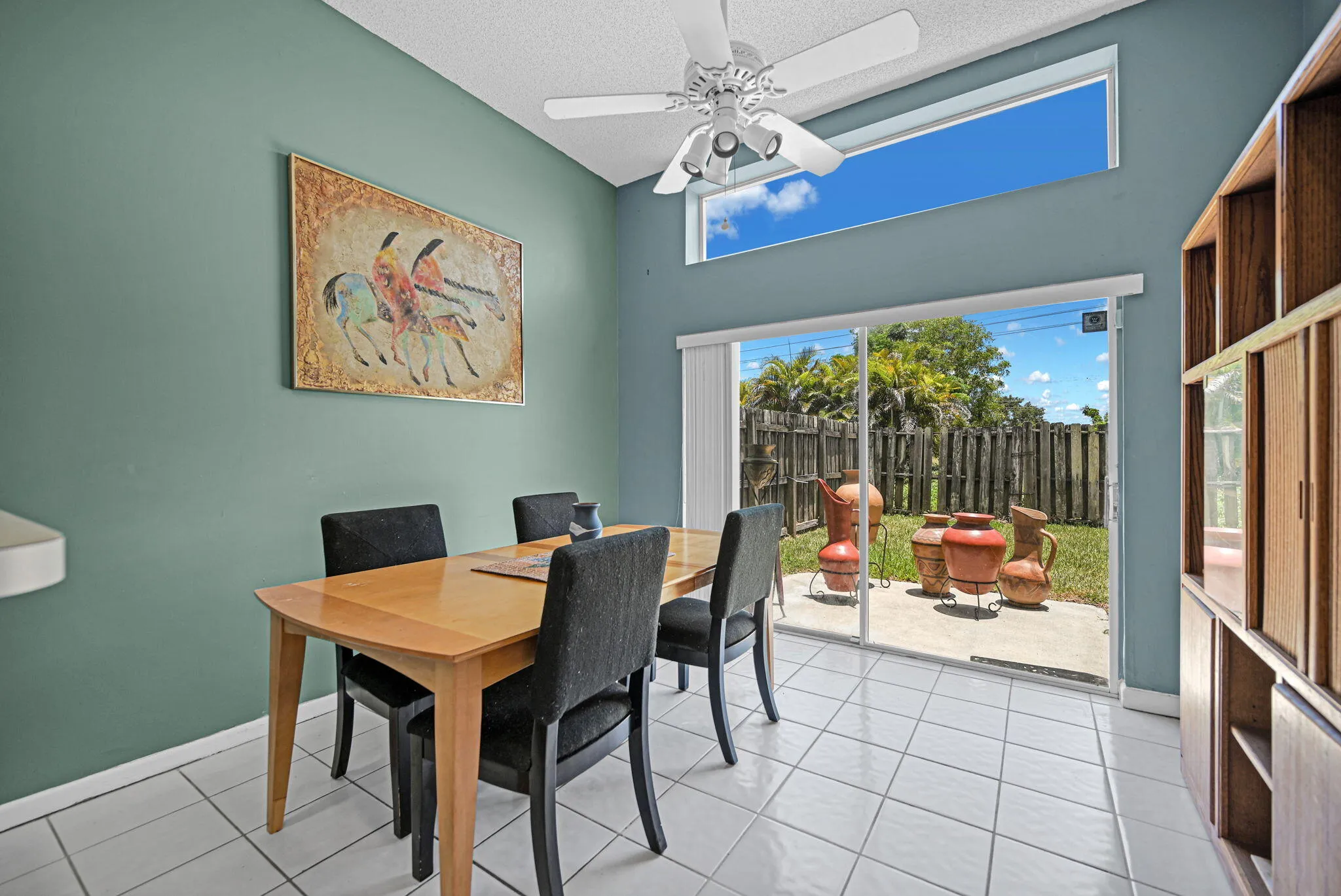Dining area featuring vaulted ceilings, a transom window, and white tile flooring