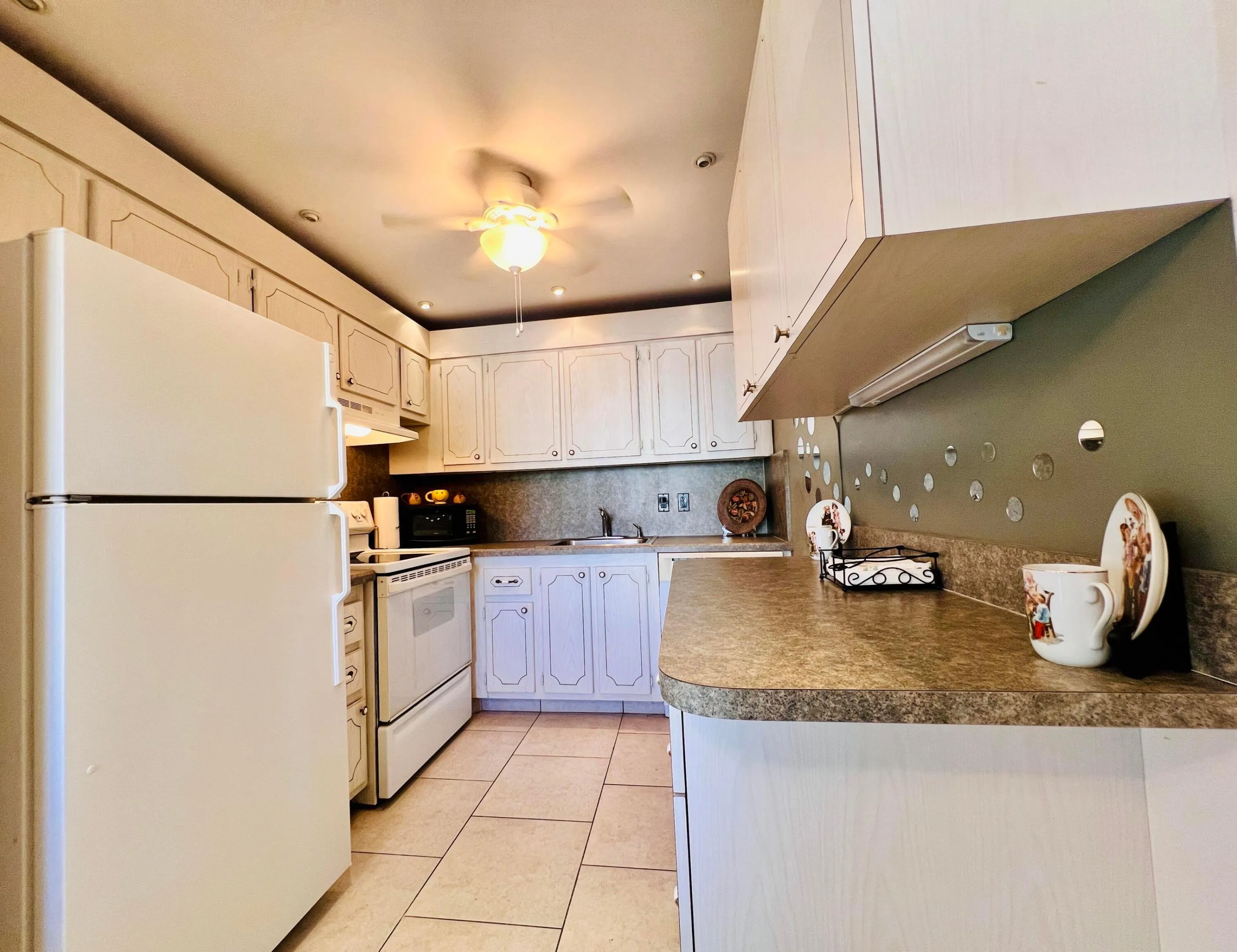 Well Maintained Kitchen With Extra Cabinet & Counter Space. Crisp White Appliances. Neutral Tile Flooring