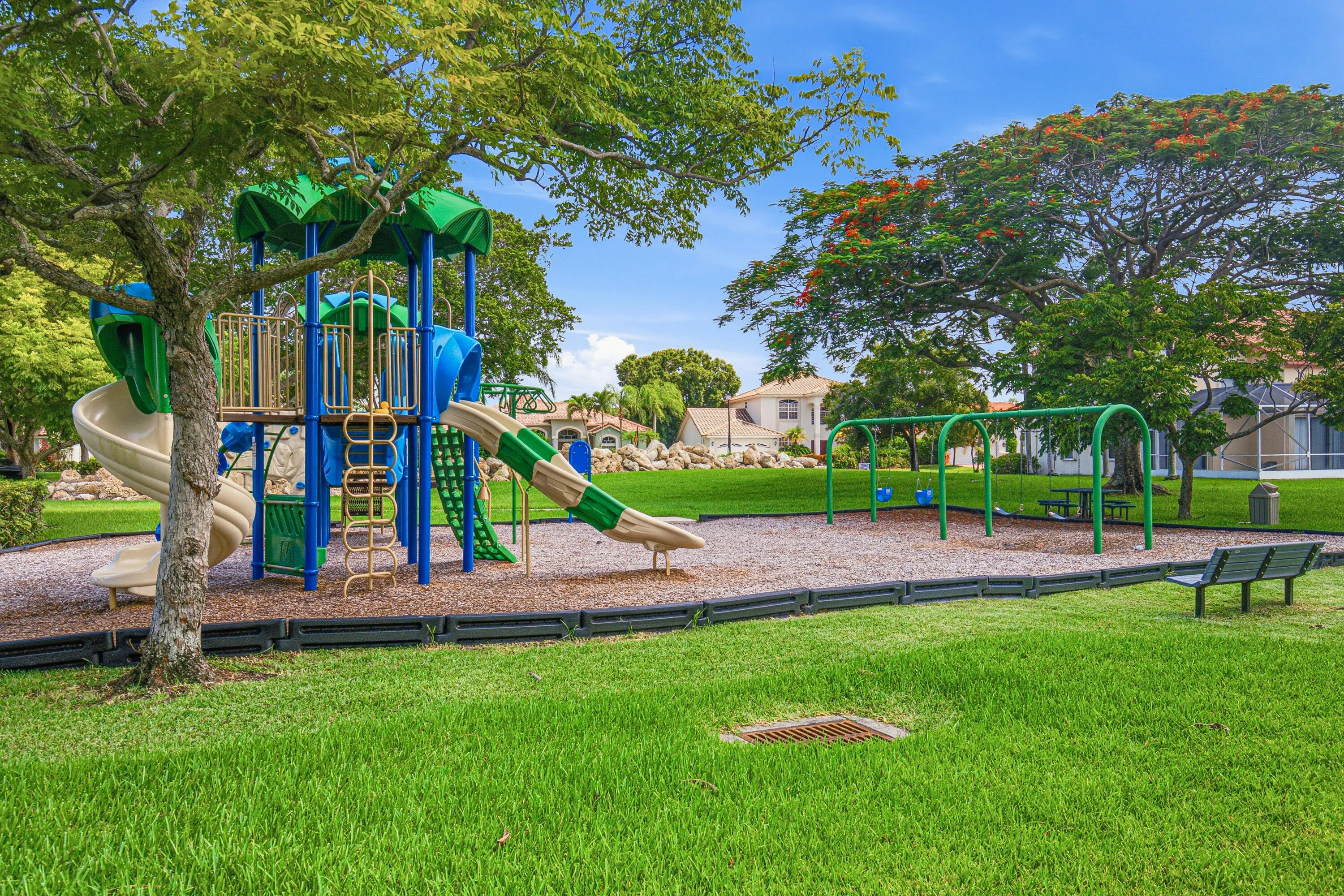 Community playground featuring a multi-level play structure with slides and climbing elements