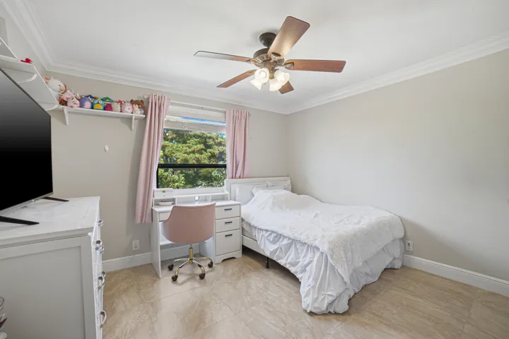 Bright room with crown molding, tiled flooring, and a ceiling fan with integrated lighting