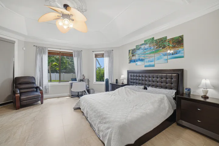 Tray ceiling featuring crown molding and a ceiling fan with light fixture