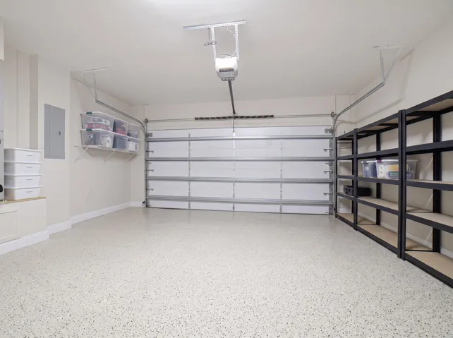 Garage featuring speckled epoxy flooring and a white sectional garage door with opener