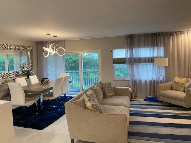 Open-concept living and dining area featuring a sliding glass door, multiple windows, and recessed lighting