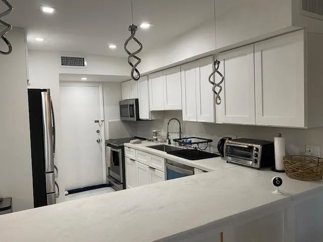 Kitchen featuring white shaker-style cabinetry, recessed lighting, and stainless steel appliances