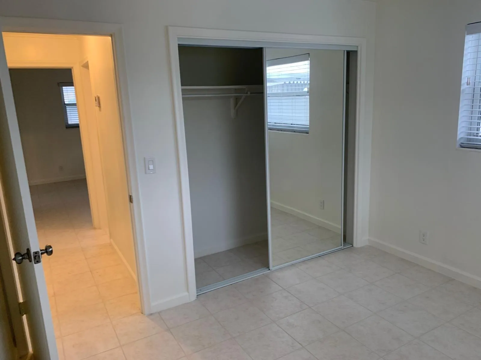Room featuring tile flooring and a mirrored closet with sliding doors
