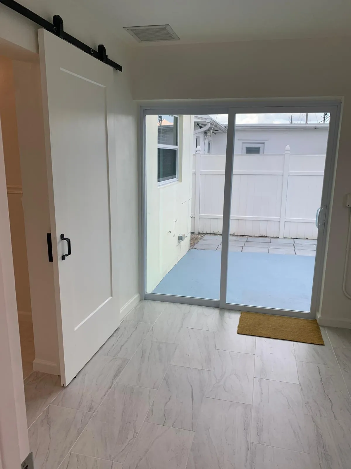 Sliding glass door leading to an outdoor patio with light blue concrete