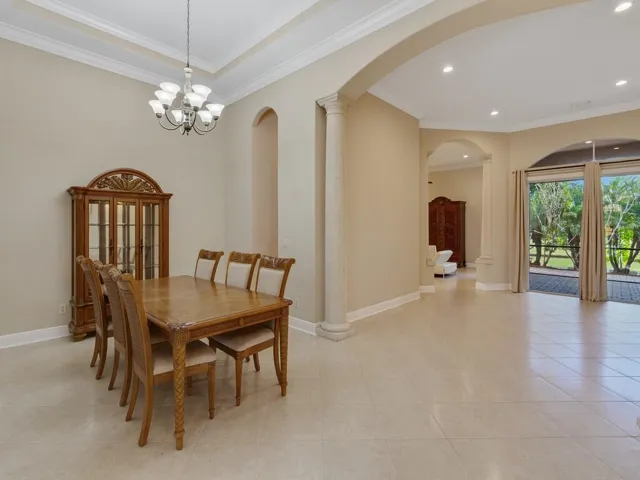 Dining room featuring decorative columns, ornamental molding, recessed lighting, and a chandelier