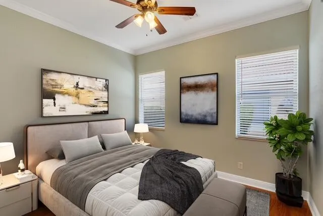 Bedroom featuring ornamental molding, a ceiling fan, and wood finished floors