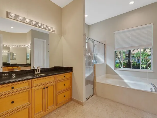Full bathroom with double vanity and a textured wall