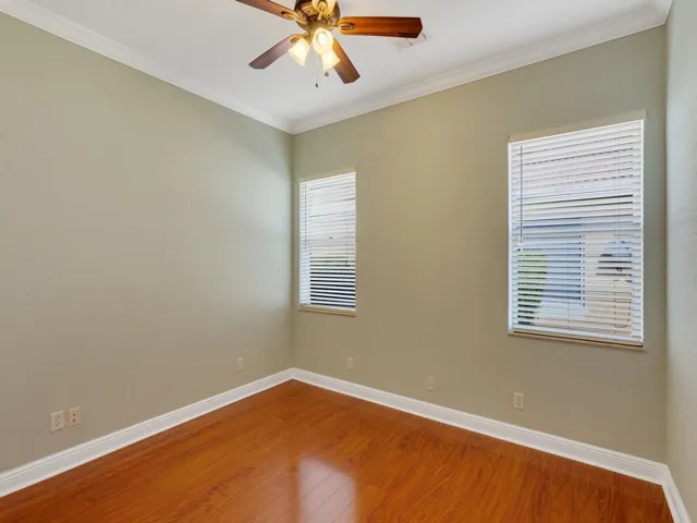 Bedroom featuring ornamental molding, a ceiling fan, and wood finished floors