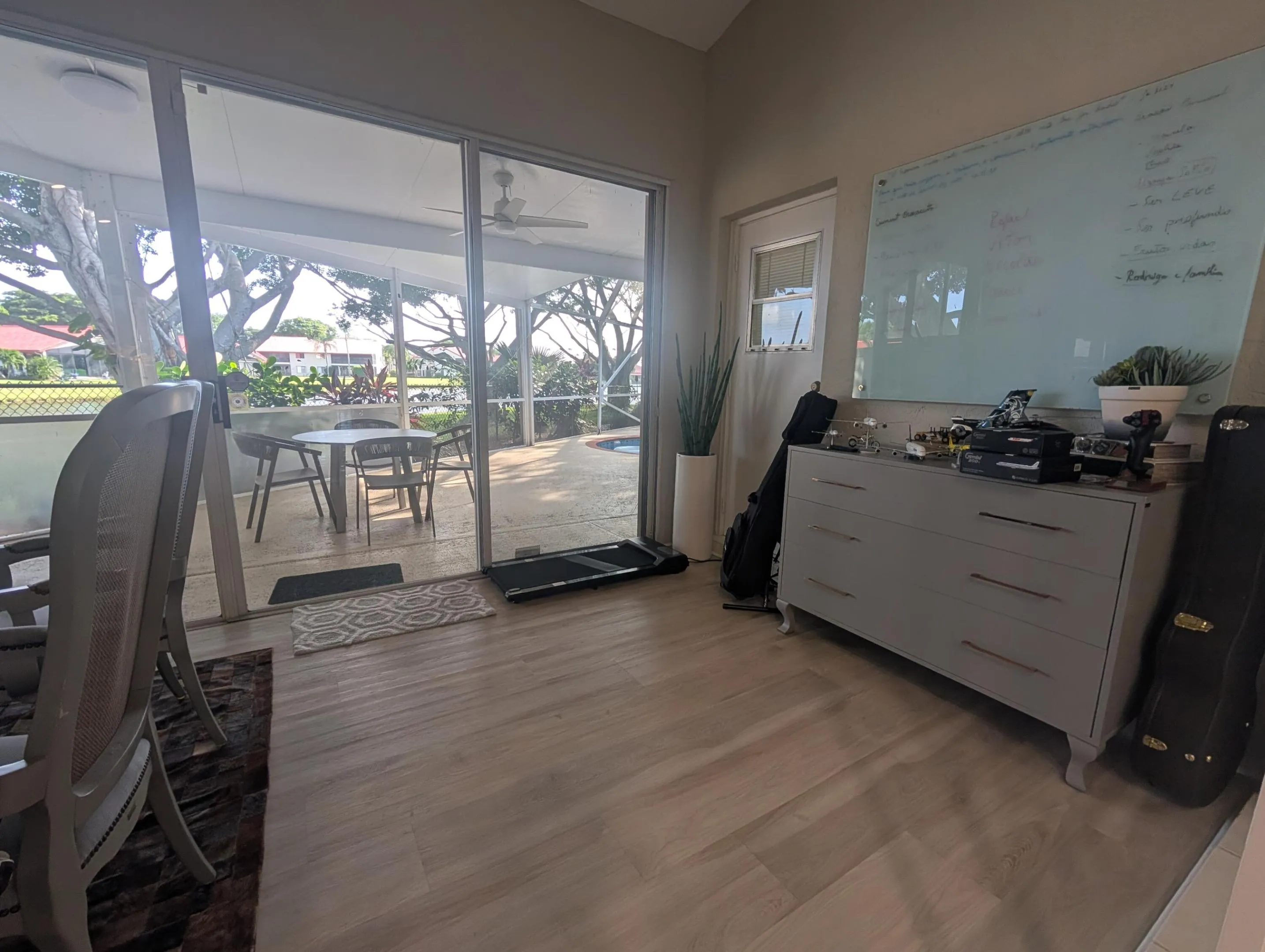 Sliding glass doors opening to a covered patio with a ceiling fan