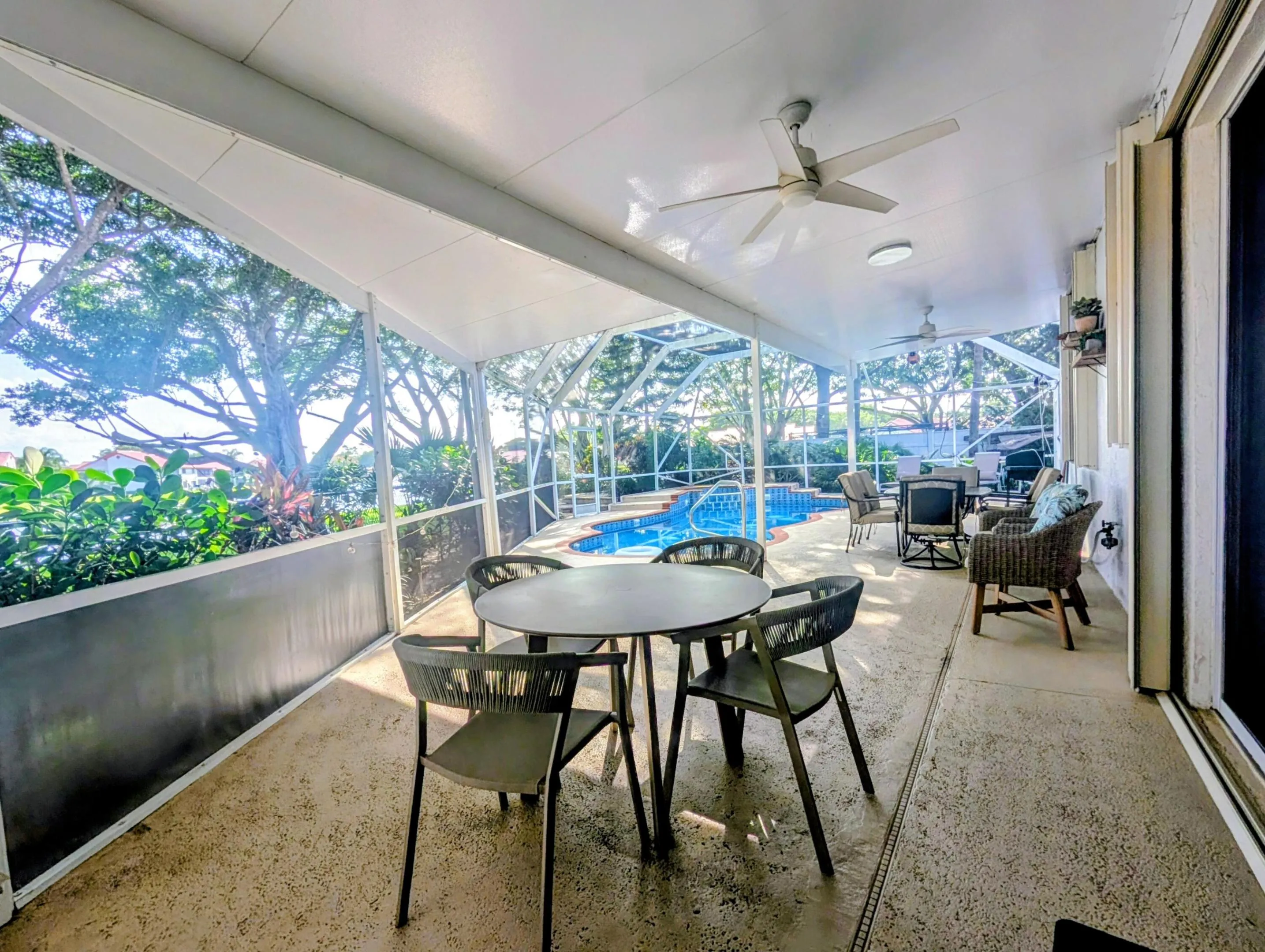 Screened-in patio with multiple ceiling fans, recessed lighting, and direct access to an in-ground swimming pool