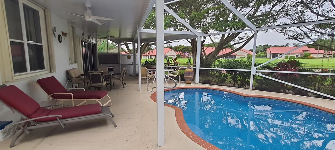 Screened-in patio with an integrated in-ground pool featuring a brick coping