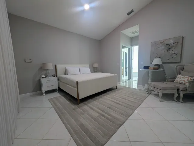 Spacious interior featuring vaulted ceilings and white tile flooring
