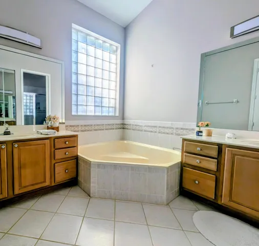 Corner soaking tub with tiled surround and decorative accent tile