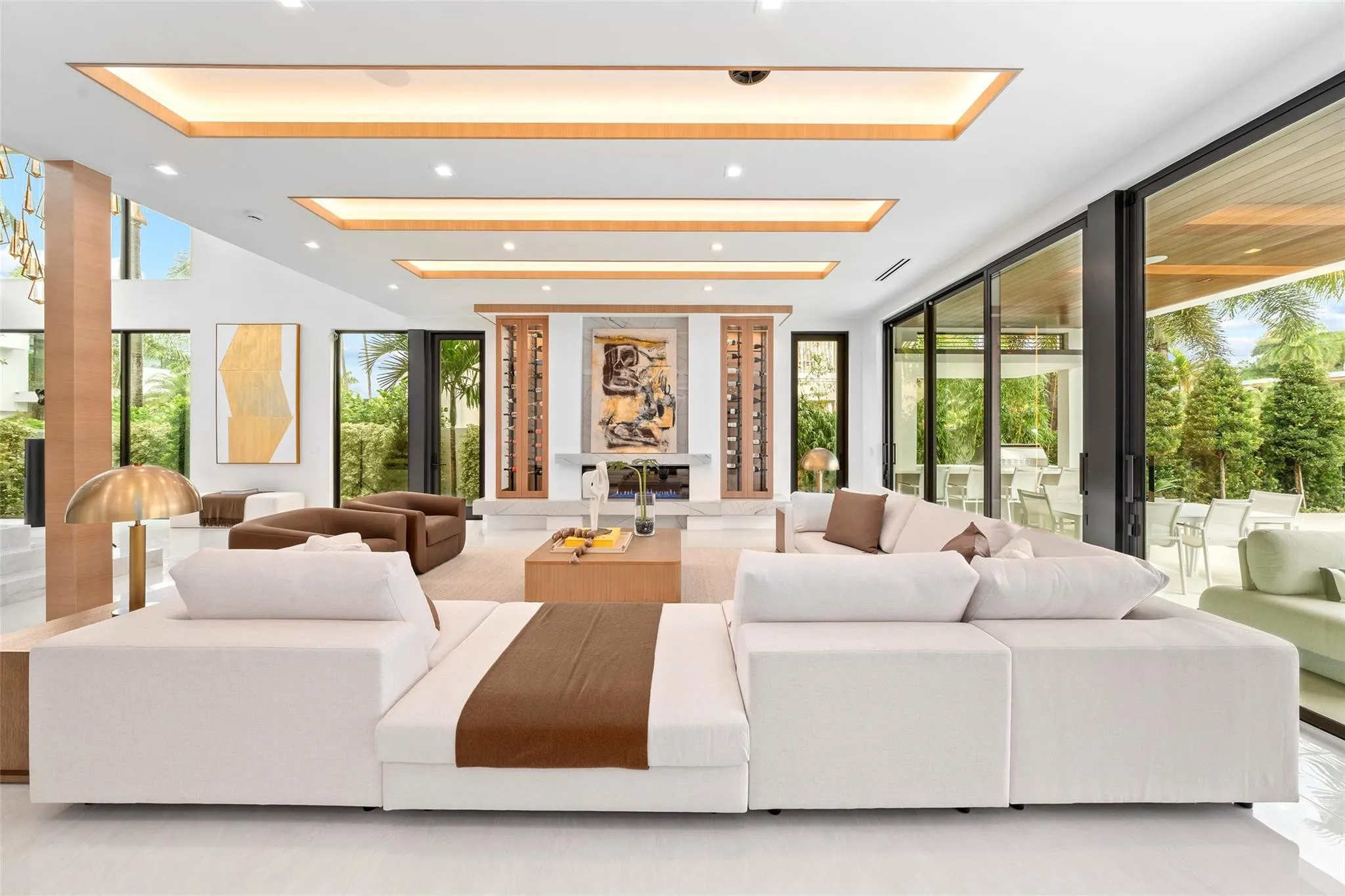 A beautifully designed formal living area with soaring ceilings, expansive windows, and stunning waterway views. The open layout seamlessly connects the living, dining, and outdoor spaces, creating an exceptional setting for waterfront entertaining.