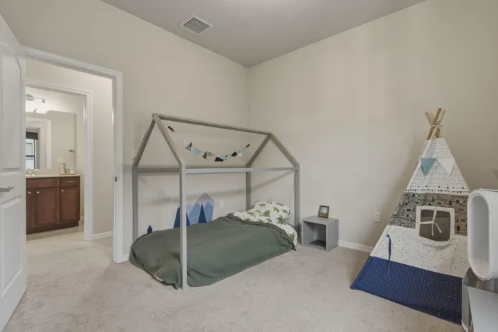 Carpeted bedroom with a vaulted ceiling and a neutral wall color