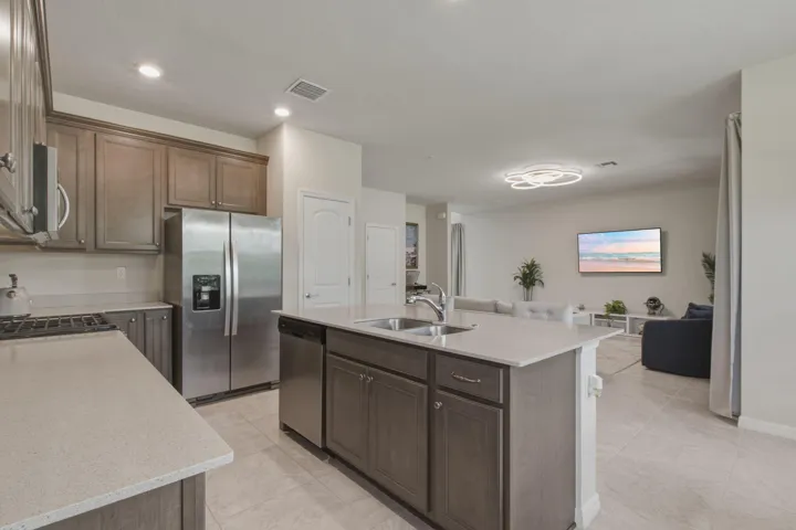 Kitchen with a central island featuring a stainless steel sink and a stainless steel dishwasher