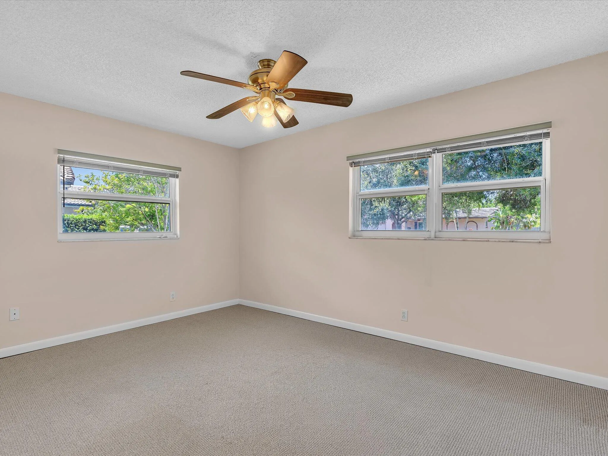 Neutral-toned room featuring light beige carpeting and matching wall color