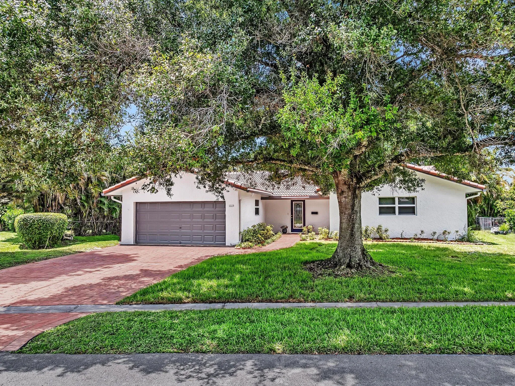Single-story residence featuring a white stucco exterior and a red tile roof