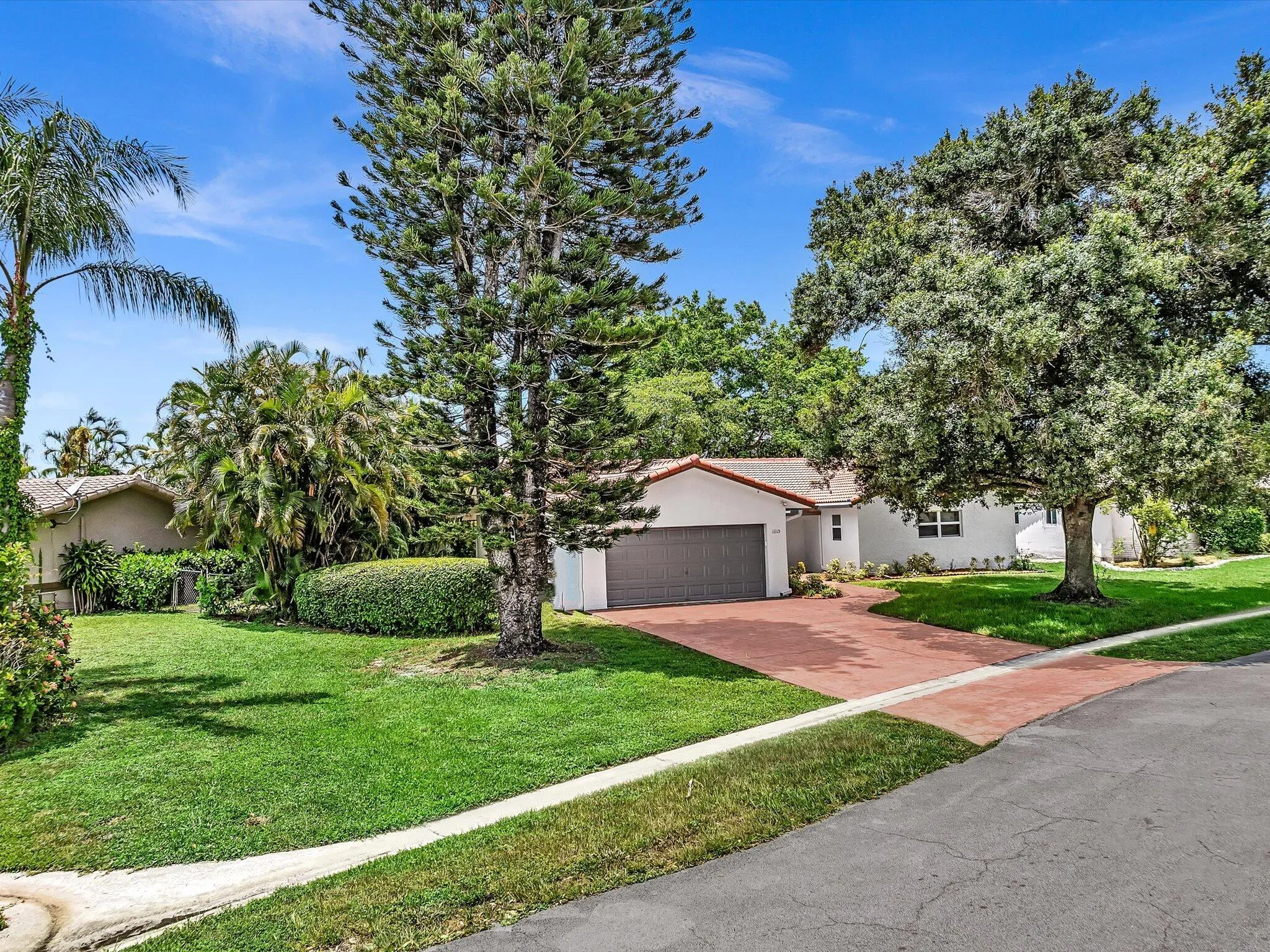Single-story residence featuring a tile roof and a paver driveway