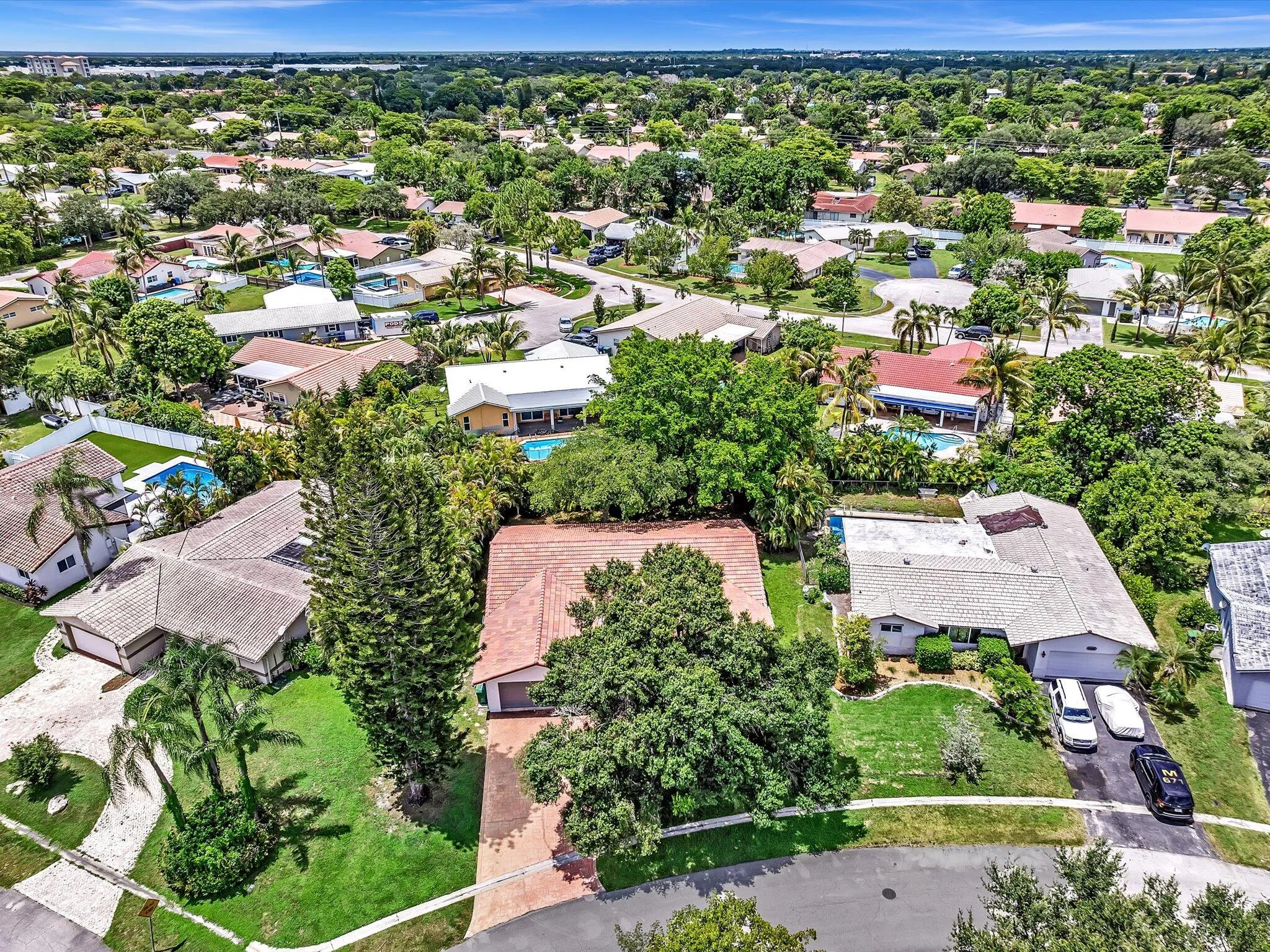 Expansive residential area featuring numerous properties surrounded by mature trees and lush landscaping