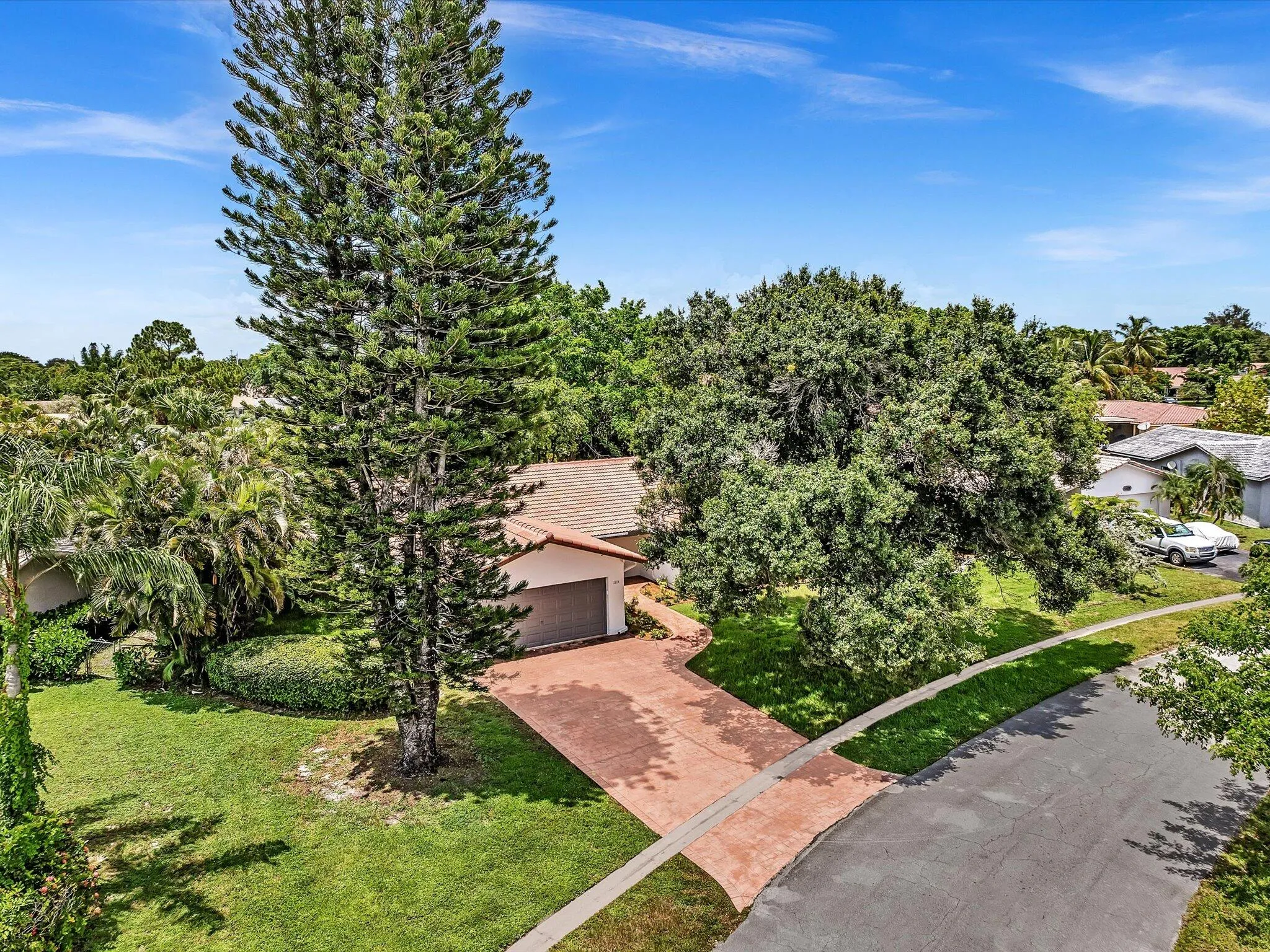 Single-story residence featuring a tile roof, an attached garage, and a stamped concrete driveway