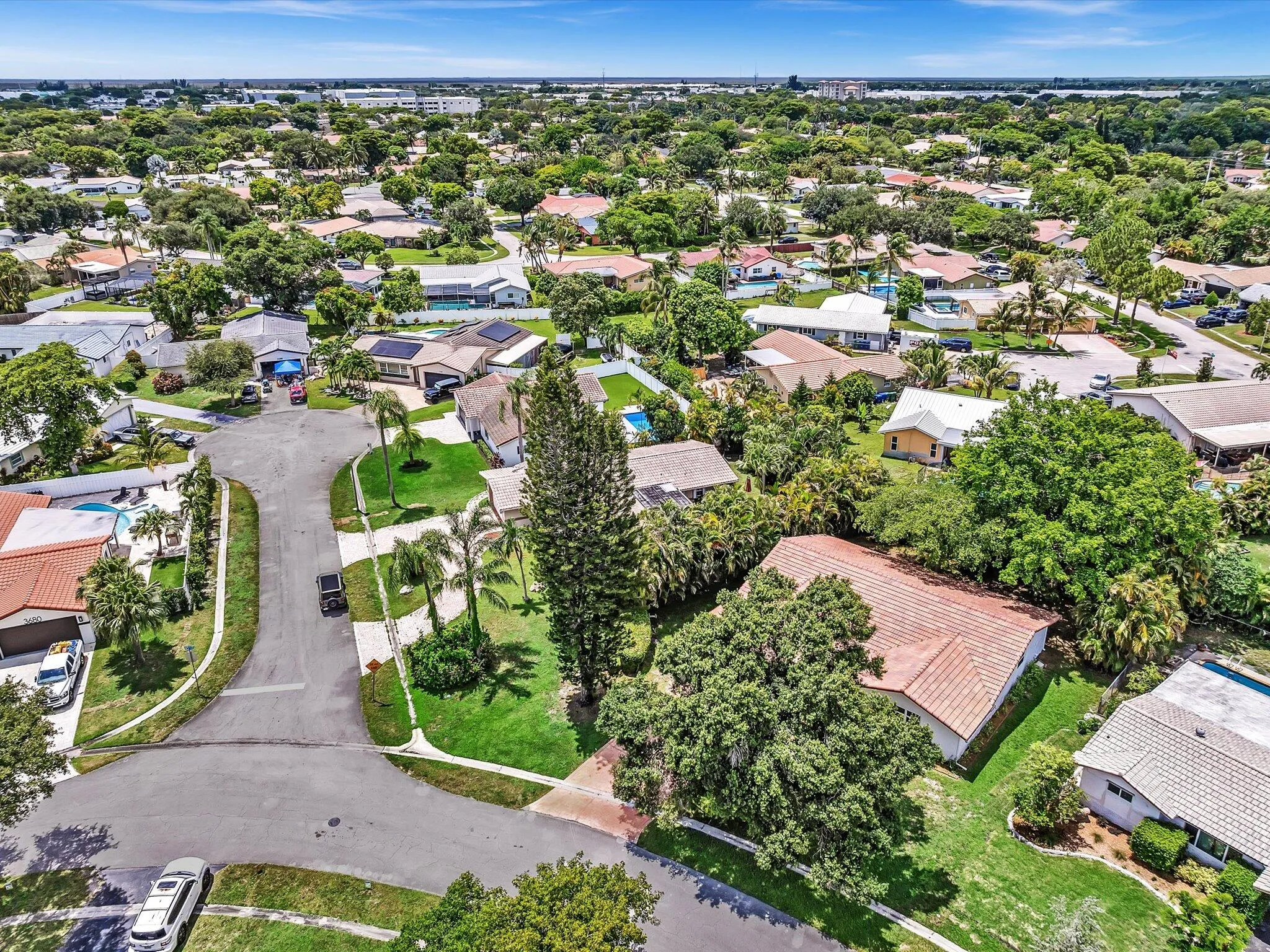 Aerial perspective showcasing a residential neighborhood with mature landscaping and clear skies