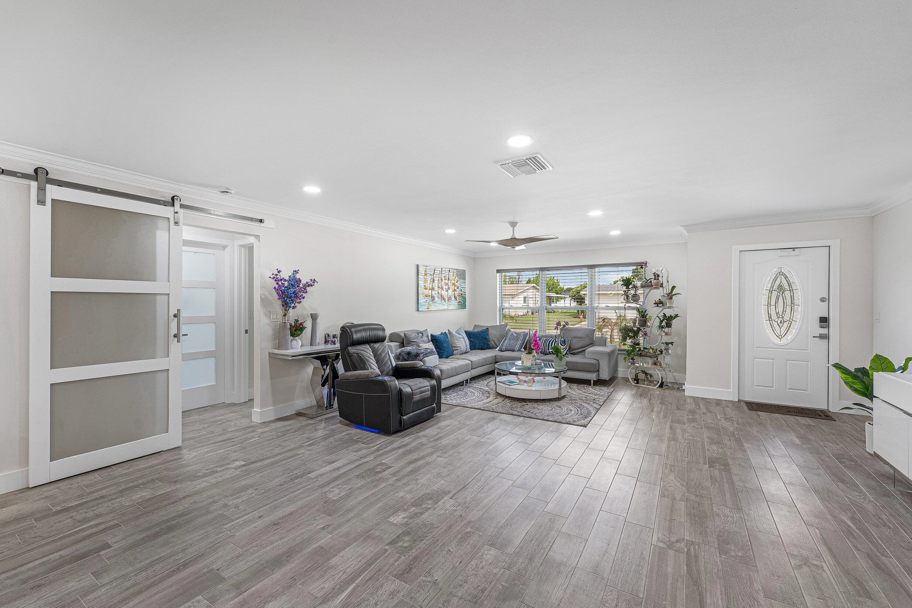 Spacious living area featuring wood-finish flooring, recessed lighting, and a contemporary ceiling fan