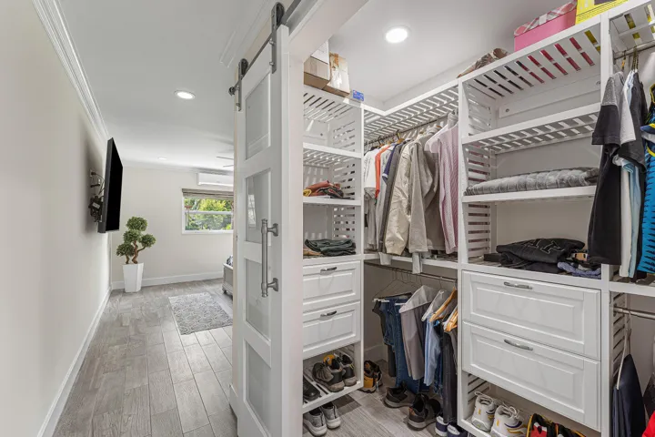 Custom closet system featuring white slatted shelving and integrated drawers