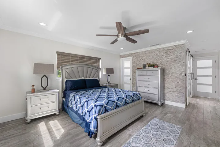 Spacious room featuring wood-finish flooring and a textured accent wall