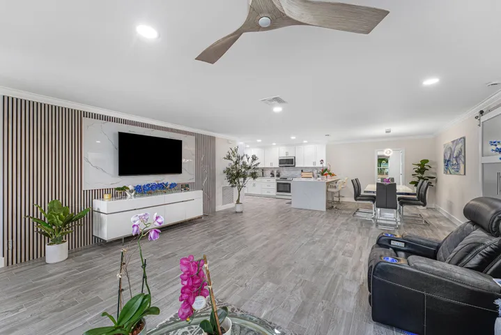 Open-concept living space featuring wood-finish flooring, recessed lighting, and a modern ceiling fan