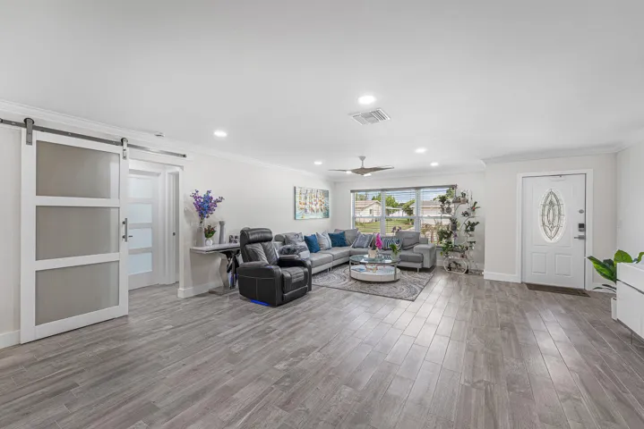 Spacious living area featuring wood-finish flooring, recessed lighting, and a contemporary ceiling fan