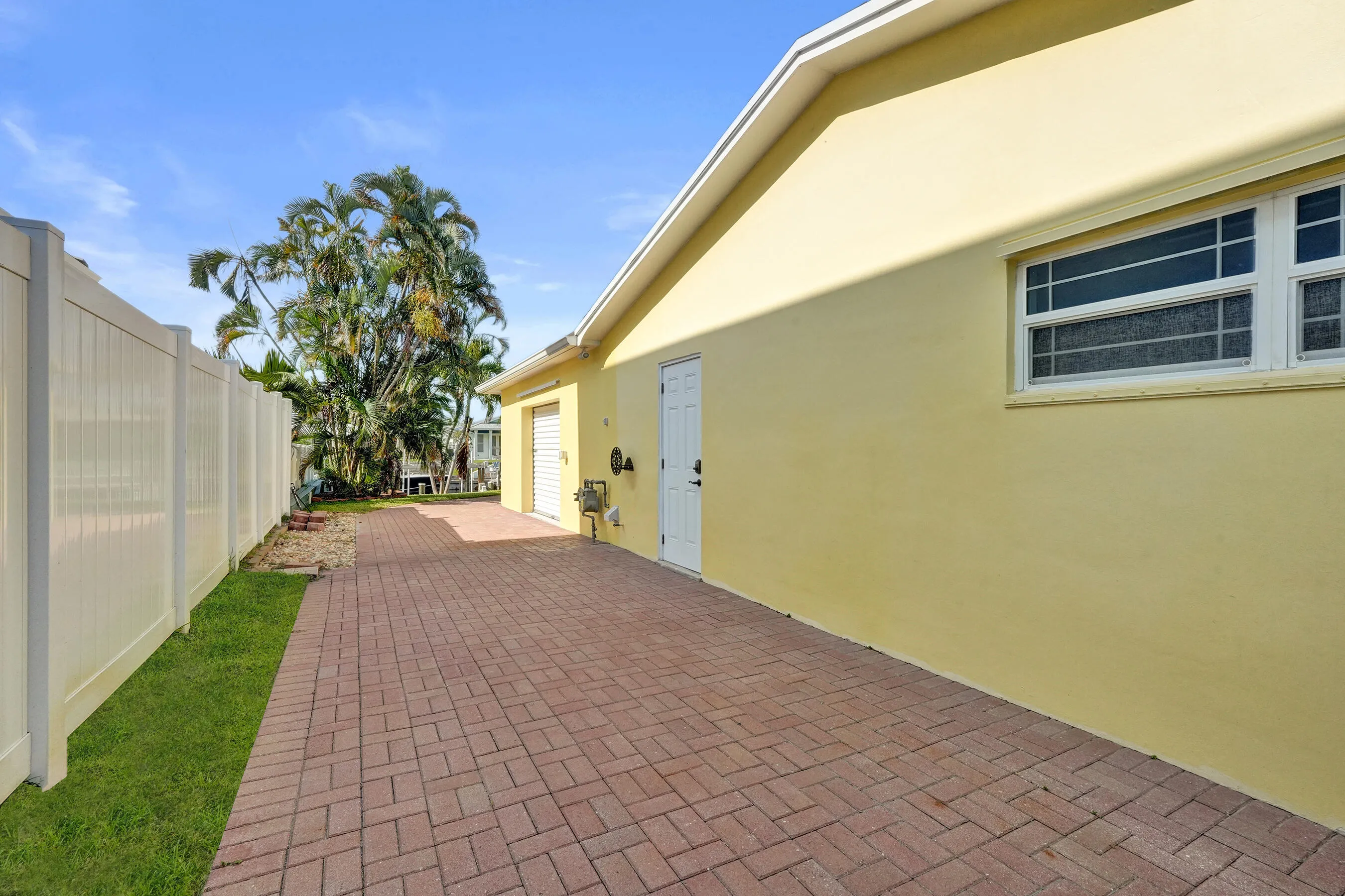Side yard with 30 AMP RV hookup. Side pedestrian door to garage and workshop beyond.