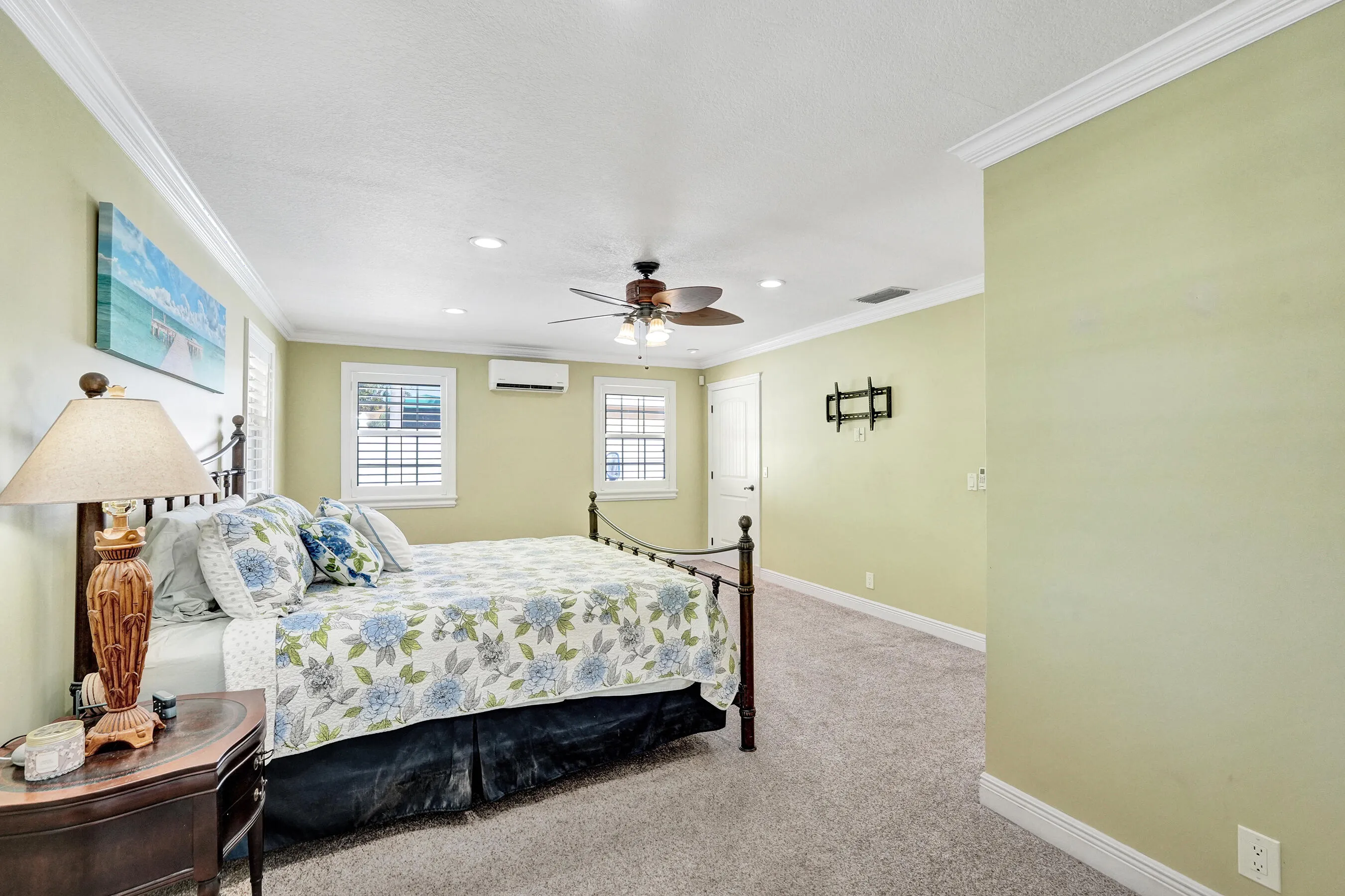 Huge 21' x 18' Master bedroom featuring crown molding, recessed lighting, a ceiling fan, 3 closets and windows with plantation shutters.