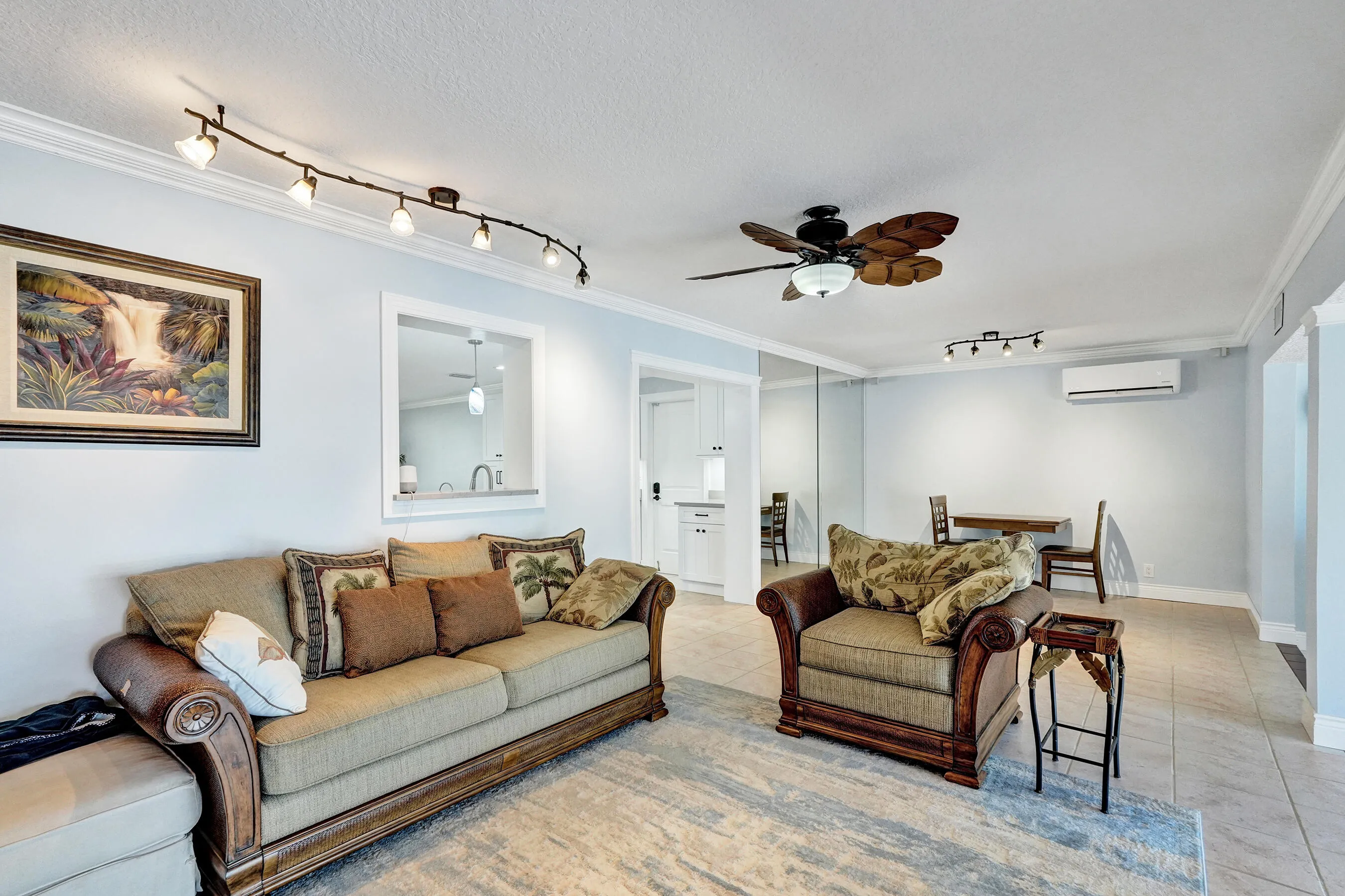 Family room featuring neutral wall tones, crown molding and a pass-through window to the kitchen.