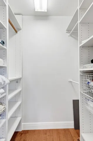 Custom closet system featuring multiple adjustable shelves, a clothes rod, and wire basket drawers