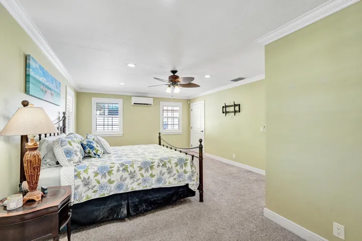 Huge 21' x 18' Master bedroom featuring crown molding, recessed lighting, a ceiling fan, 3 closets and windows with plantation shutters.