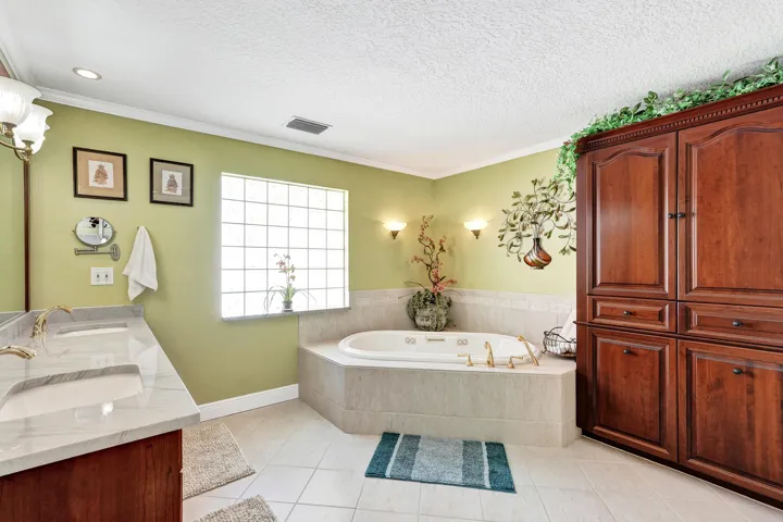 Master bathroom features a 2 person jacuzzi, custom cherry built-in cabinets and a double shower. This spacious bathroom measures 16 x 12.
