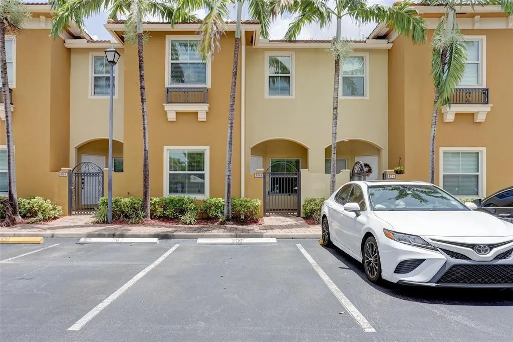 Multi-story exterior featuring a warm stucco finish and a tile roof
