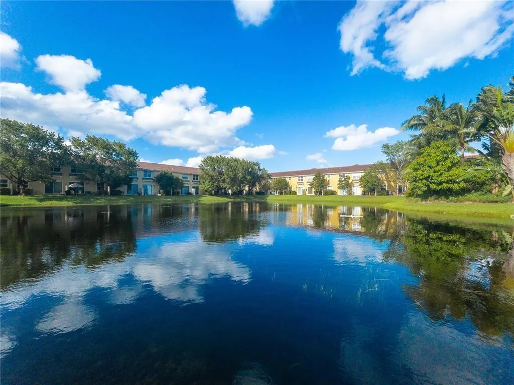 Lakefront property featuring a landscaped shoreline and mature trees
