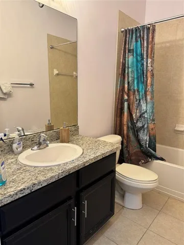 Bathroom featuring a dark wood vanity with a light granite countertop and an undermount sink