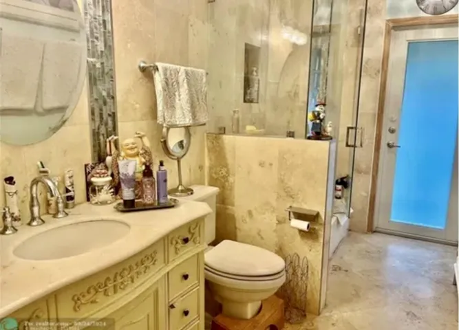 Bathroom featuring a single vanity with an integrated sink, polished chrome faucet, and decorative cabinetry