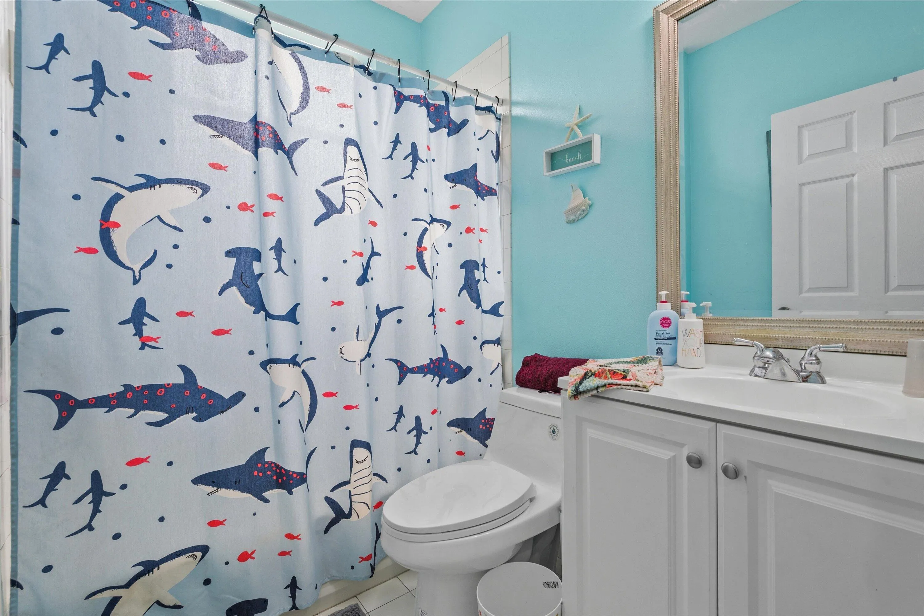 Bathroom featuring a single vanity with white cabinetry, a built-in sink, and a chrome faucet