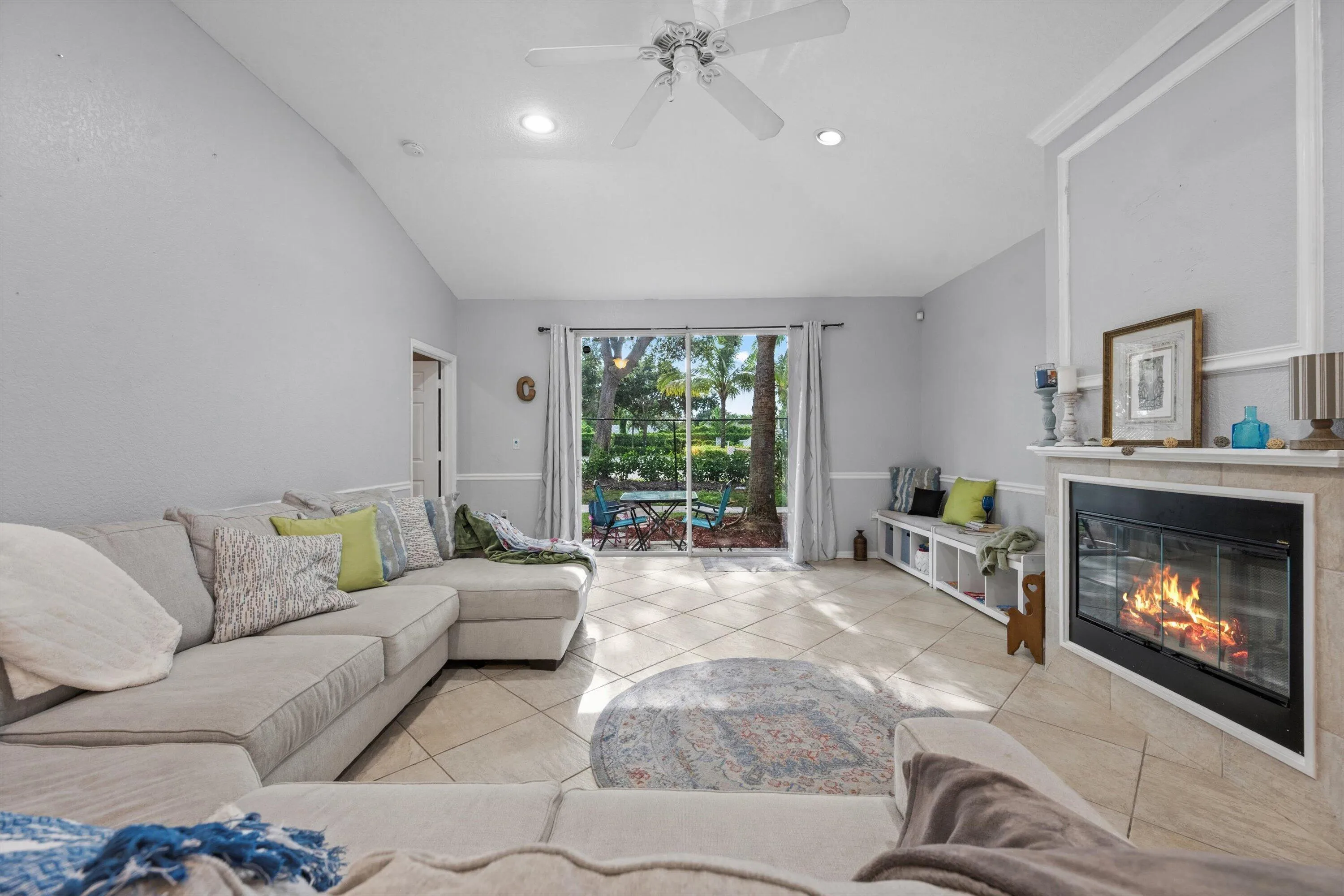 Living area featuring vaulted ceilings, recessed lighting, and tile flooring